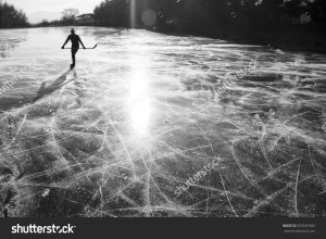 stock-photo-alone-hockey-player-on-frozen-ice-during-ice-skating-on-natural-ice-in-rural-environment-359561903